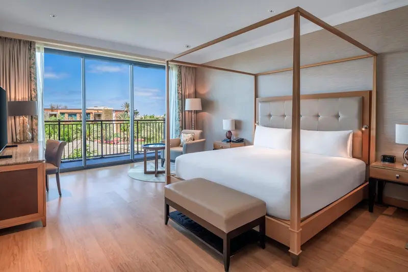 Une chambre lumineuse avec un grand lit à baldaquin et une vue sur l'extérieur.