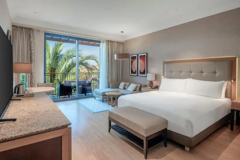 Une chambre lumineuse avec un grand lit et un accès à une terrasse.