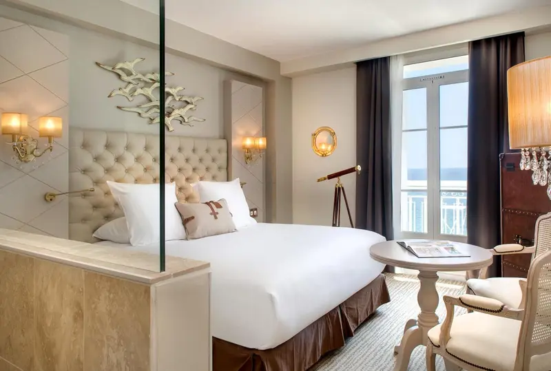 Une chambre lumineuse avec un grand lit et une vue sur la mer.