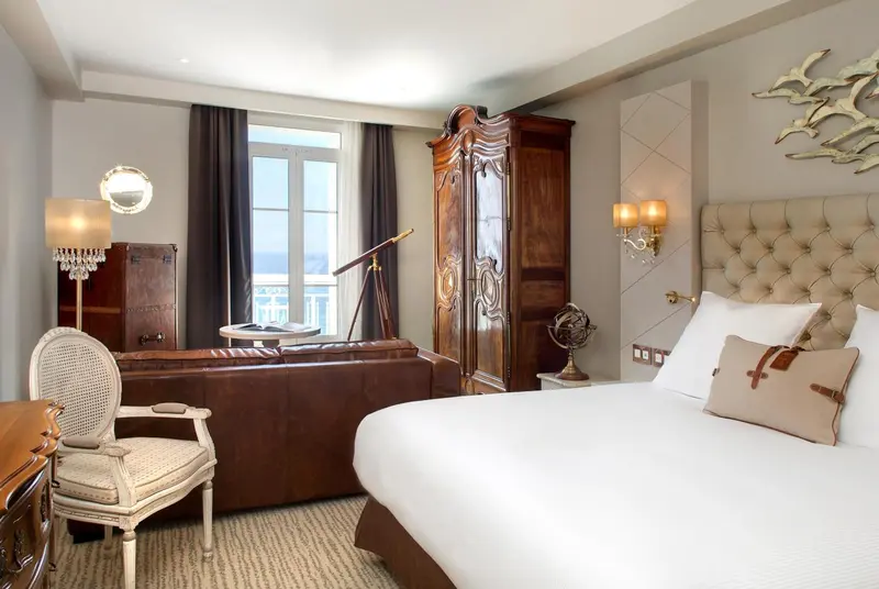 Une chambre lumineuse avec un lit confortable et un coin salon.