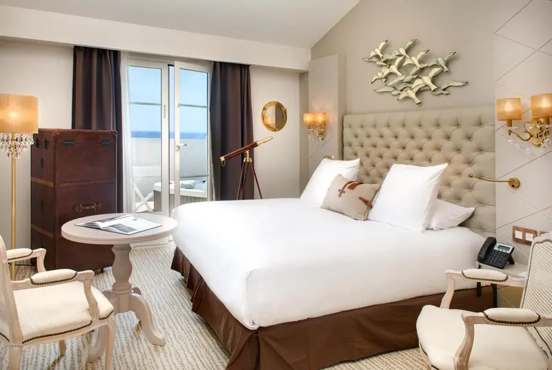 Une chambre lumineuse avec un grand lit et un balcon.