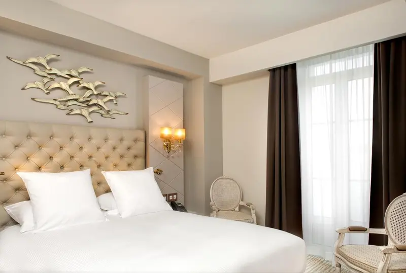 Une chambre lumineuse avec un grand lit recouvert d'une courtepointe matelassée.