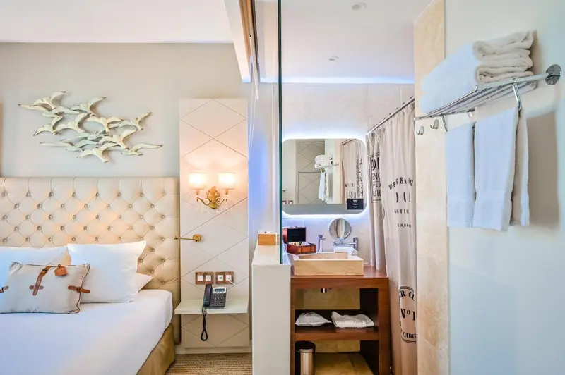 Une chambre lumineuse avec un lit confortable et une salle de bain attenante.