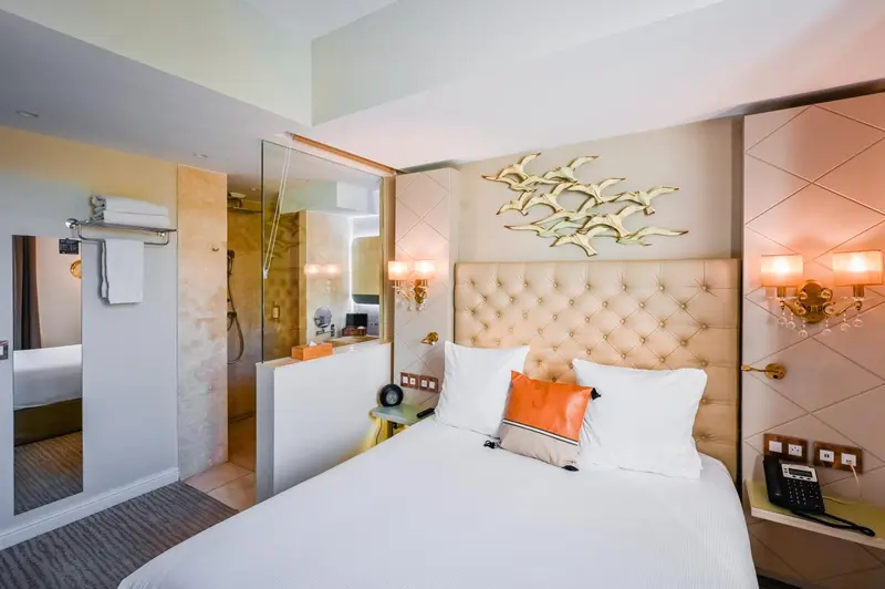 Une chambre d'hôtel lumineuse avec un grand lit et une décoration murale.