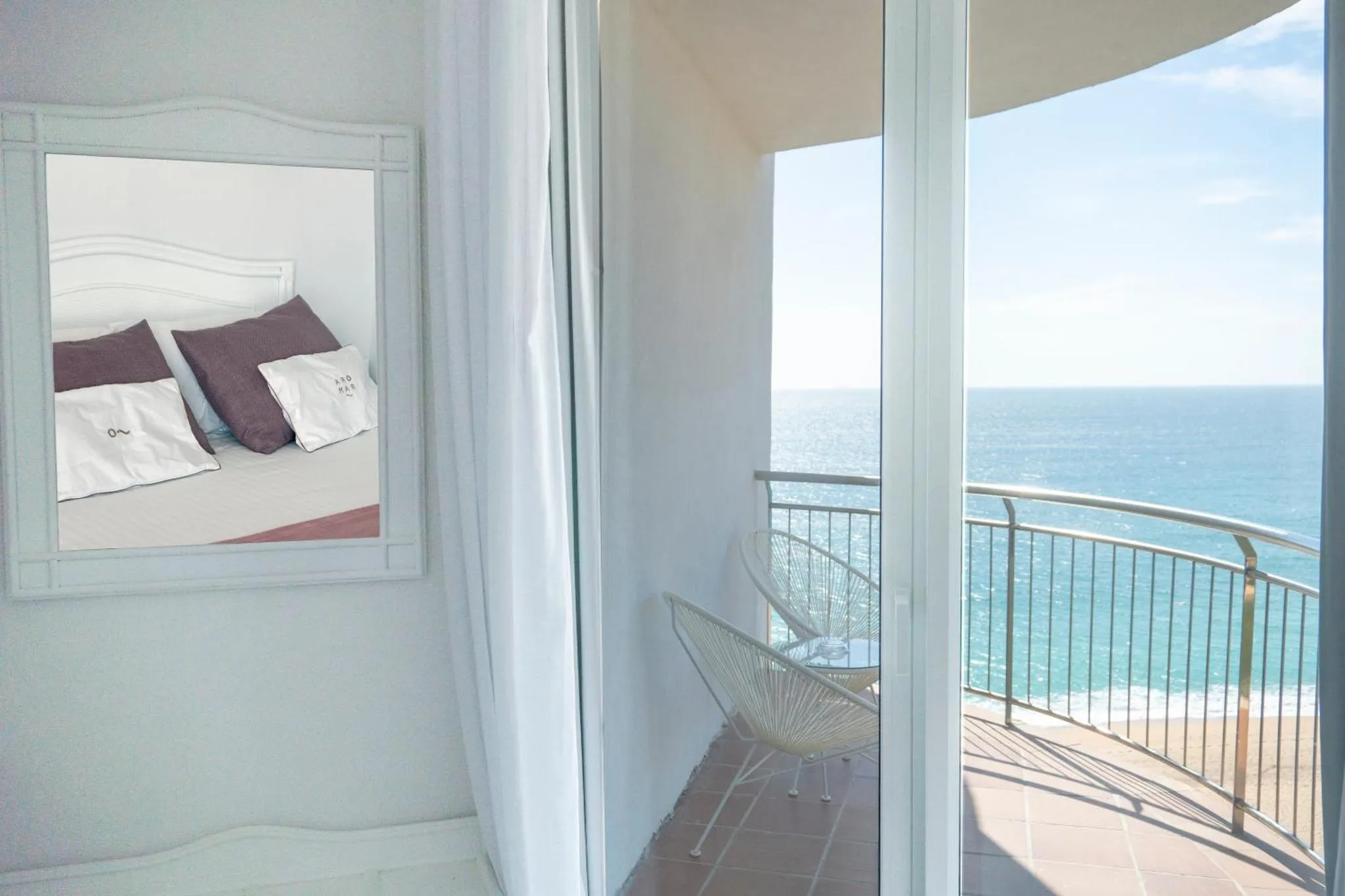 Une chambre lumineuse s'ouvre sur une terrasse avec vue sur la mer.