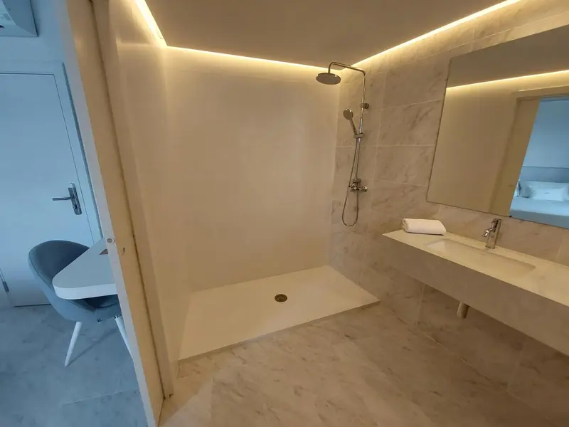 Une douche à l'italienne moderne dans une salle de bain lumineuse.