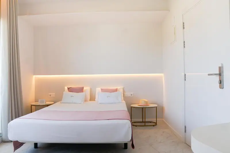 Une chambre lumineuse avec un grand lit et une décoration minimaliste.