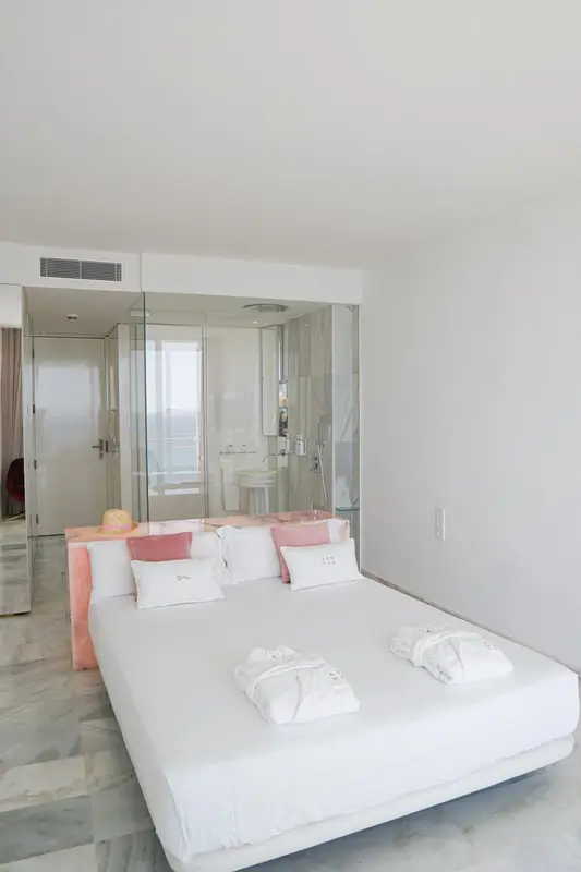 Une chambre lumineuse avec un grand lit et une salle de bain attenante.