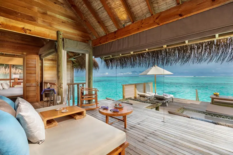 Espace de détente avec canapés et vue sur l'océan turquoise.
