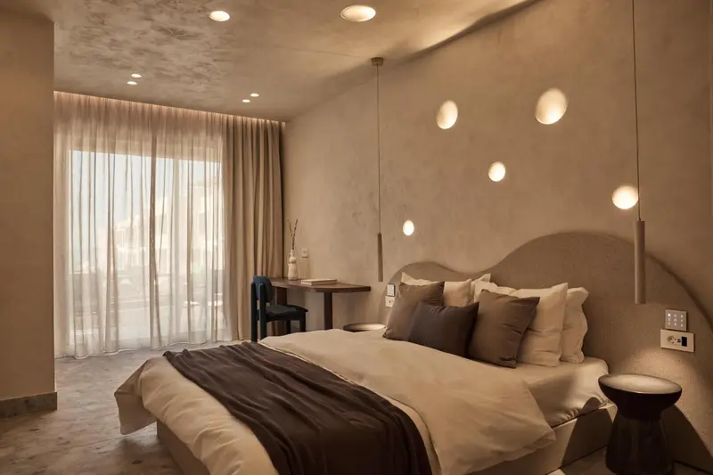 Une chambre à coucher avec un grand lit et un bureau près d'une fenêtre.