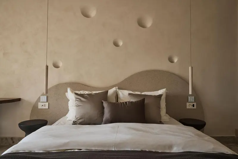 Un lit double avec des oreillers dans une chambre au décor minimaliste.