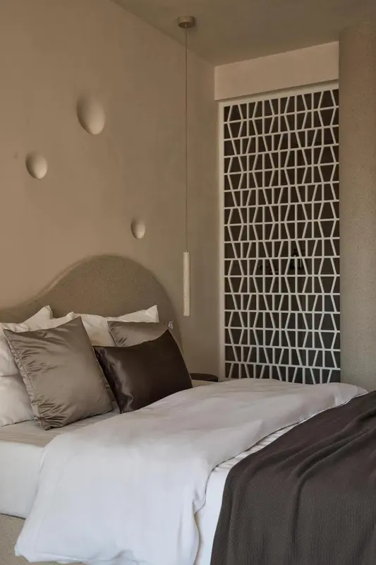 Un lit avec des oreillers et une couverture dans une chambre décorée.