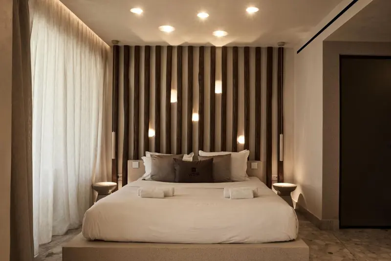 Une chambre à coucher moderne avec un grand lit et un mur décoratif.