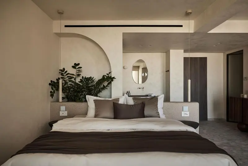 Une chambre à coucher lumineuse avec un grand lit et un décor minimaliste.