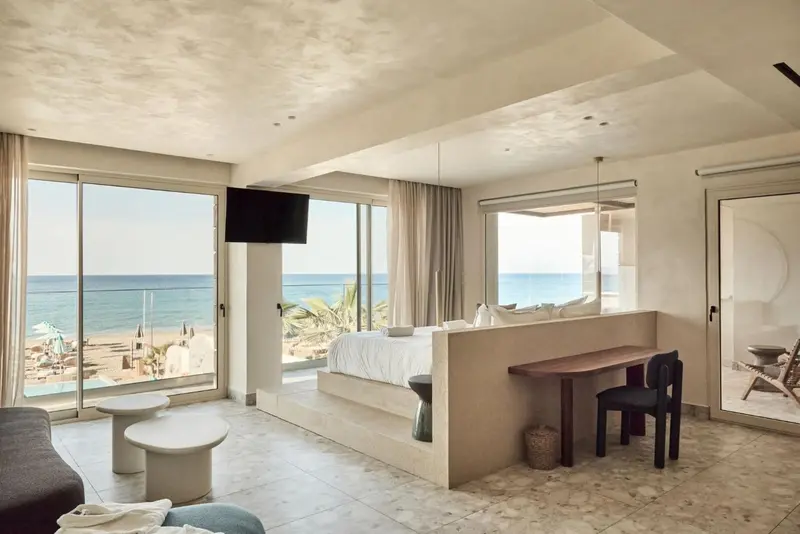 Une chambre lumineuse avec un grand lit et vue sur la mer.