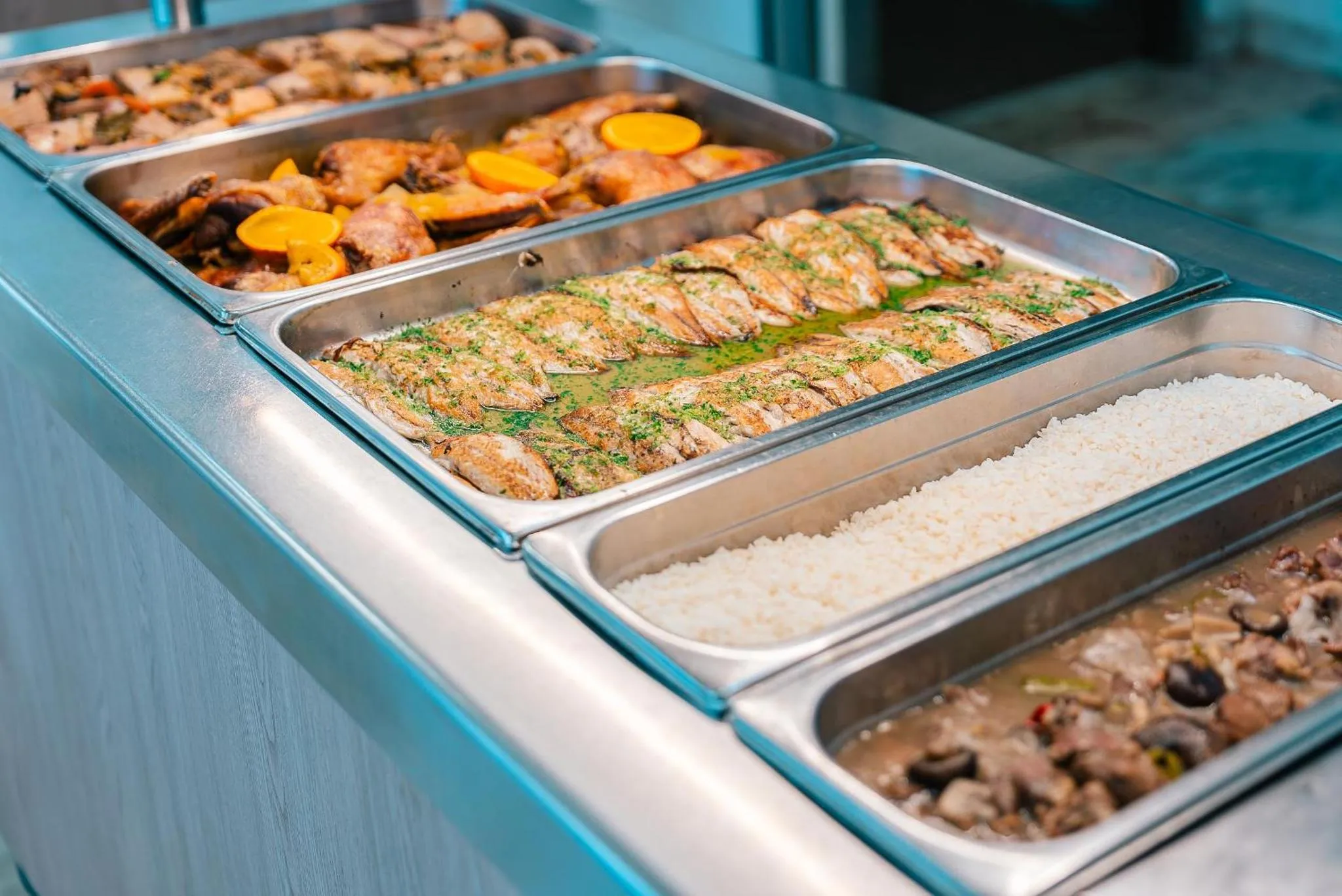 Présentation de plats variés dans des bacs en inox.