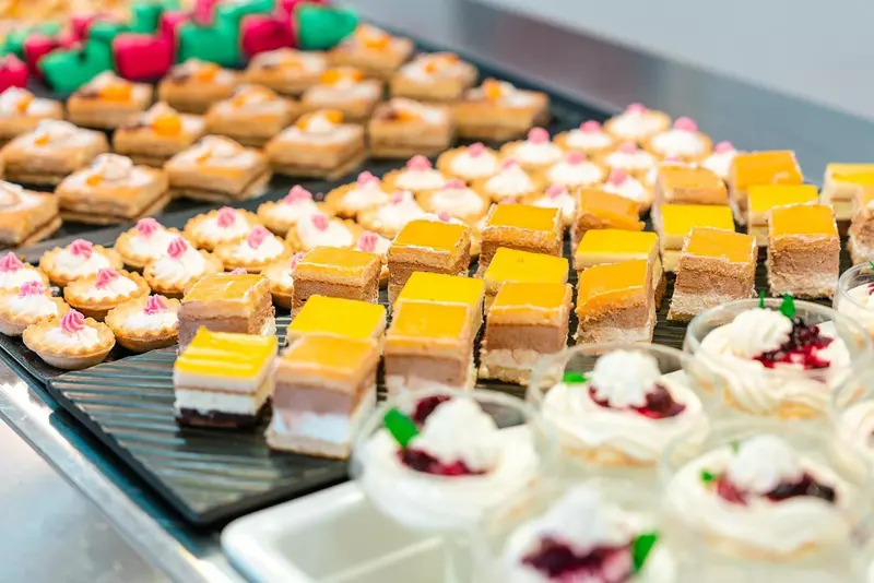 Assortiment de petites pâtisseries et de desserts présentés sur un buffet.