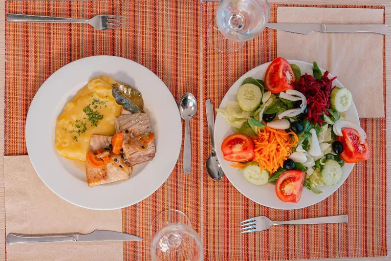Assiettes garnies de plats variés sur une table nappée.