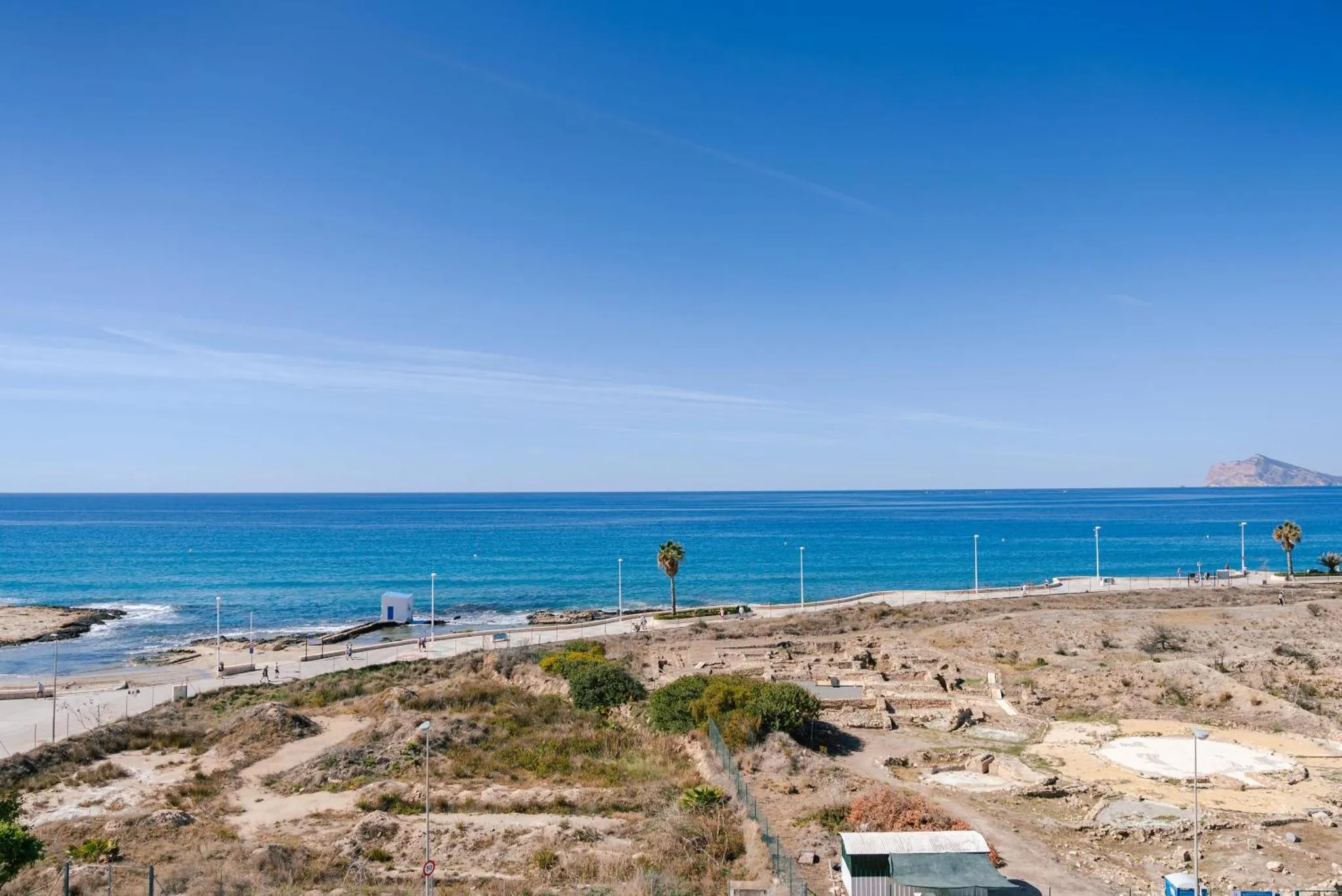 Vue sur la mer depuis une terrasse ensoleillée.