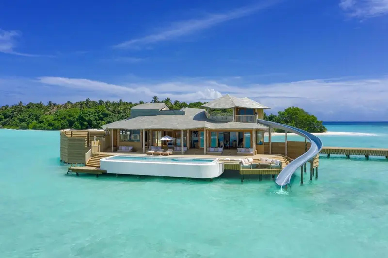 Villa sur pilotis avec piscine et toboggan aquatique.