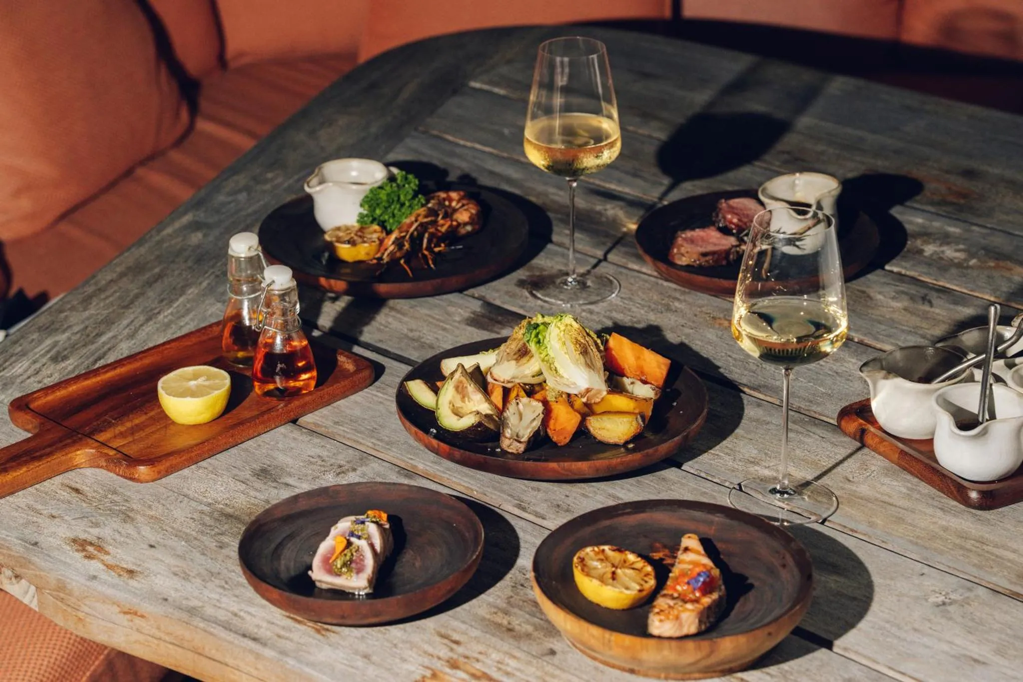 Une table en bois présente une sélection de plats raffinés et de boissons.
