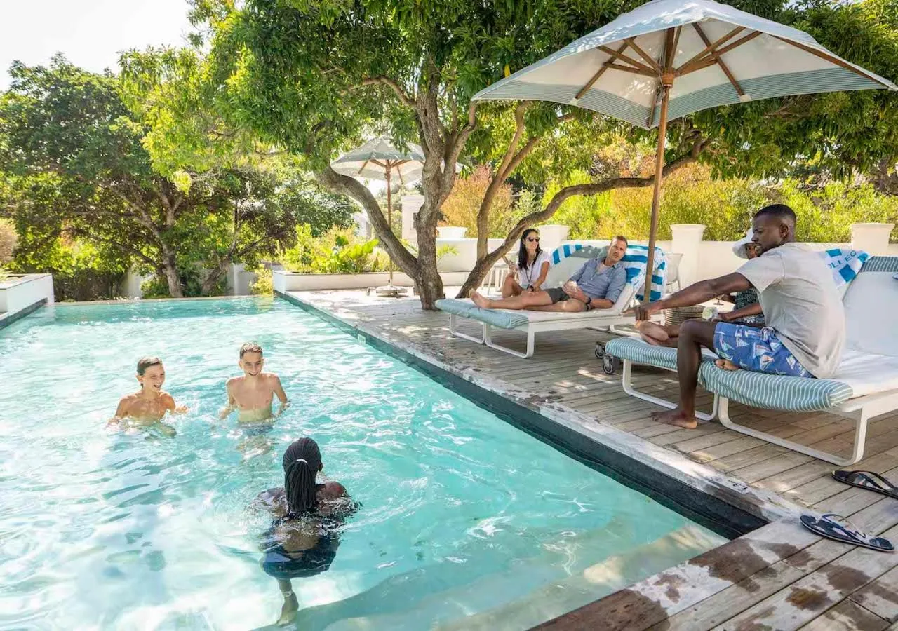 Des personnes se détendent au bord d'une piscine ensoleillée.