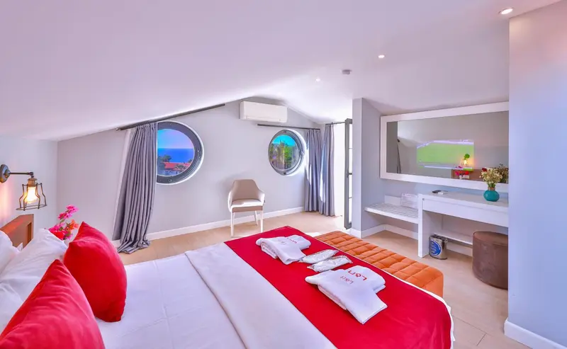 Chambre lumineuse avec un grand lit et une vue sur la mer.