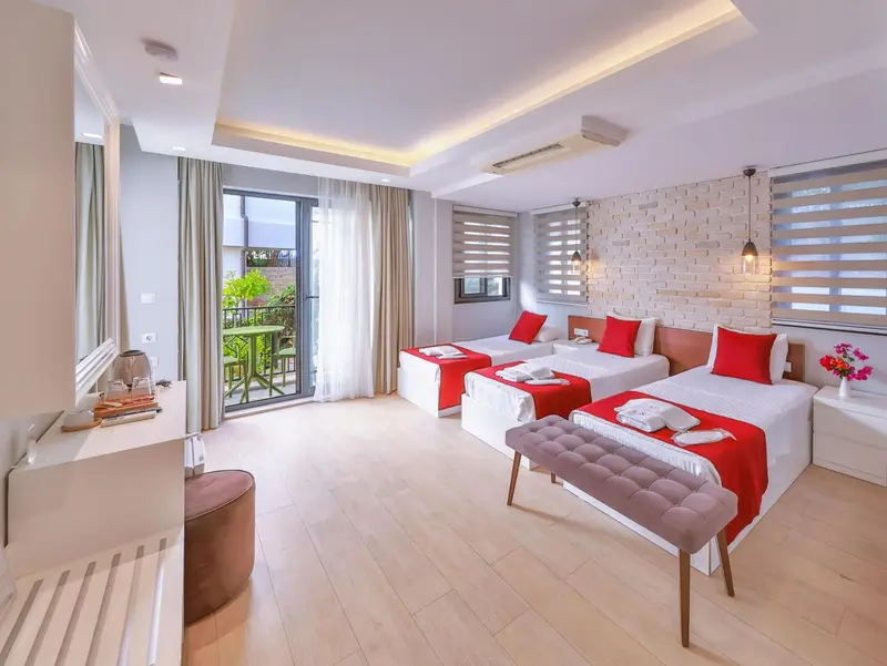 Chambre lumineuse avec deux lits simples et un accès à un balcon.