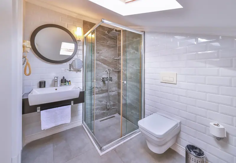 Une salle de bain moderne avec douche à l'italienne et carrelage blanc.
