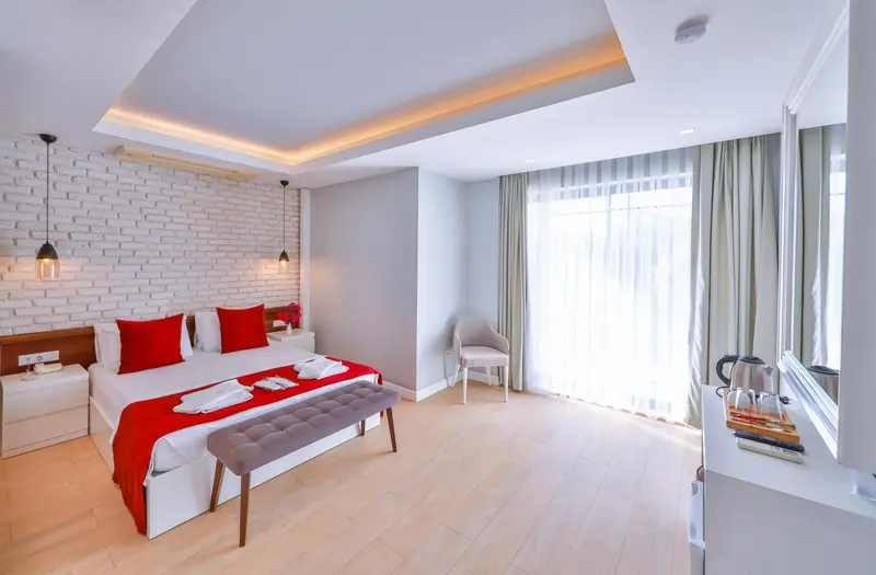 Une chambre lumineuse avec un lit double et un coin salon.