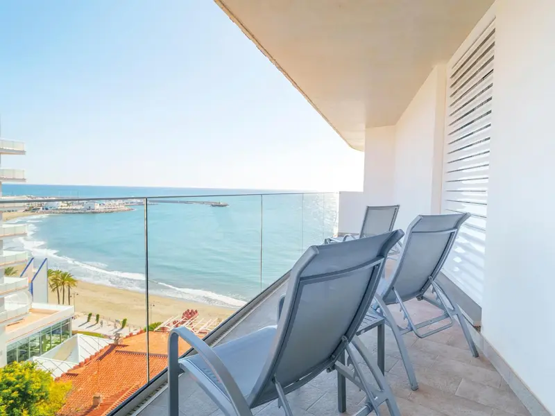 Terrasse avec chaises longues donnant sur la mer et la plage.