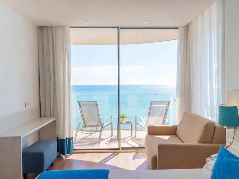 Une chambre lumineuse s'ouvre sur une vue mer et un balcon aménagé.