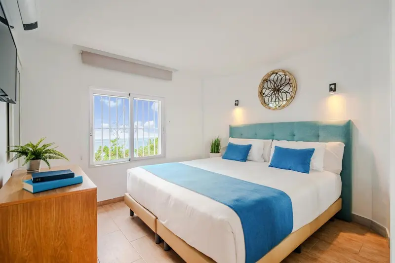 Une chambre lumineuse avec un grand lit et une vue sur la mer.