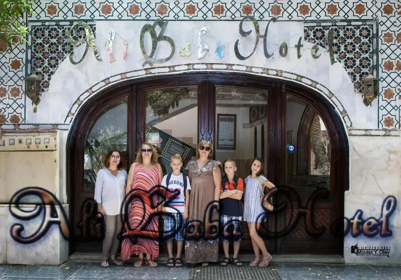 Un groupe de personnes se tient devant l'entrée d'un hôtel décoré de motifs.