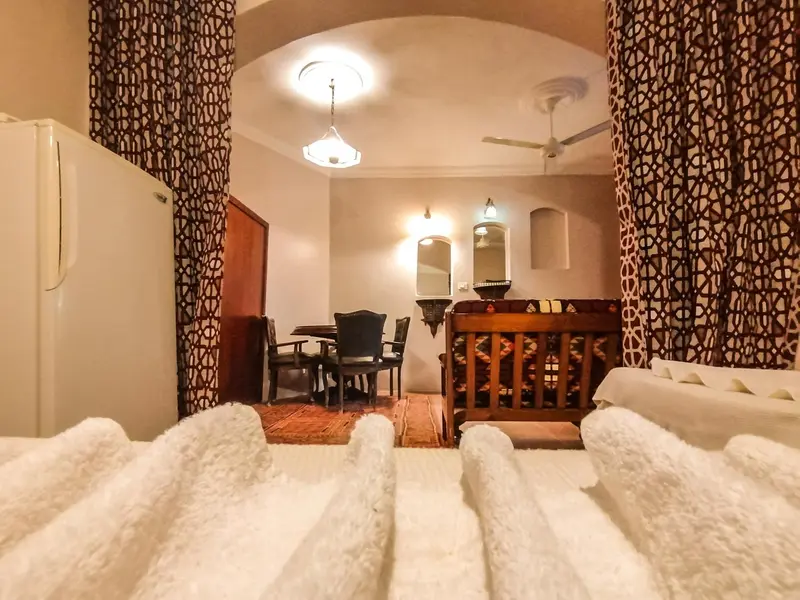 Une chambre à coucher avec un coin repas et un lit décoré de serviettes.