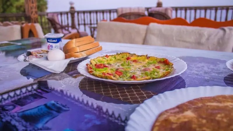 Une table est dressée avec des plats variés en extérieur.