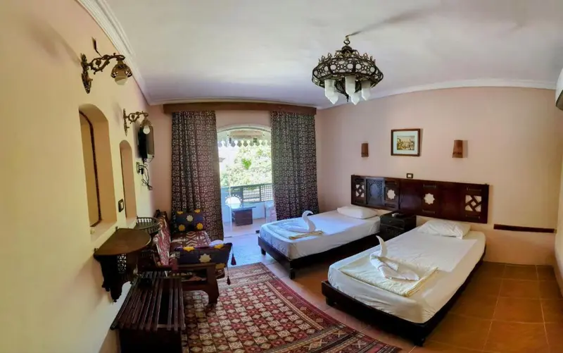 Chambre avec deux lits simples et un coin salon.
