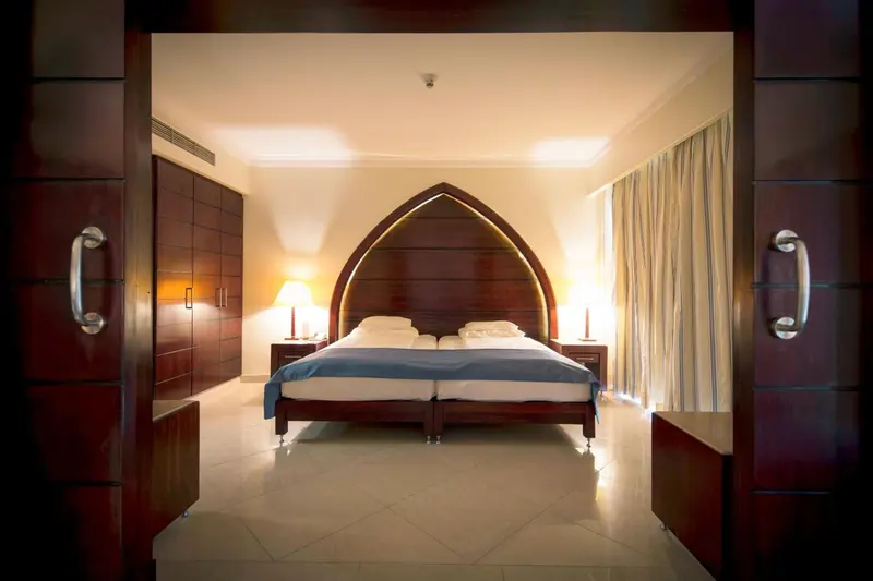 Une chambre lumineuse avec un grand lit et une décoration soignée.