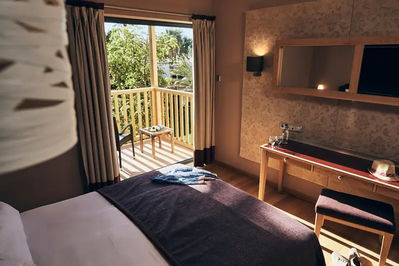Une chambre avec un lit et un accès à une terrasse ensoleillée.