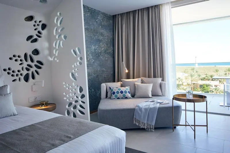 Une chambre lumineuse avec un canapé et une vue sur la mer.