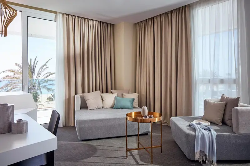 Espace de détente avec canapés et vue sur la mer à travers de larges baies vitrées.