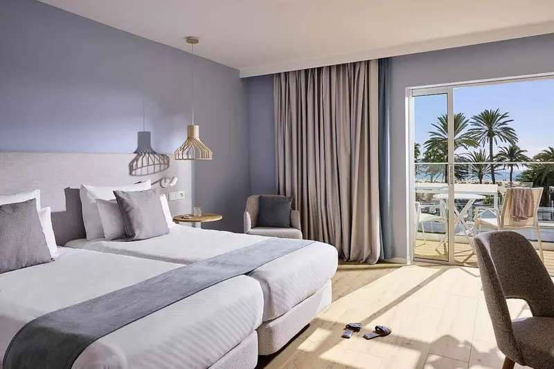 Une chambre lumineuse avec un grand lit et un accès à une terrasse.