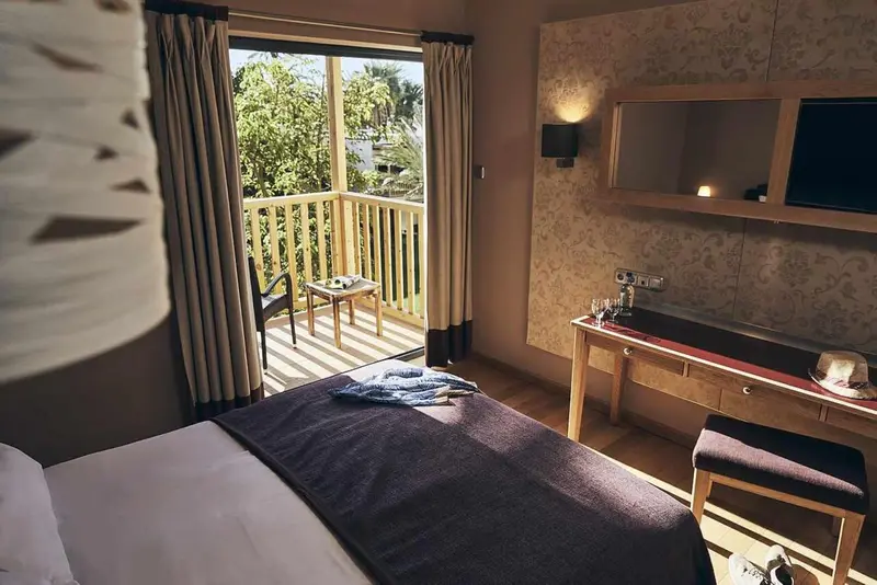 Une chambre avec un lit et un accès à une terrasse.