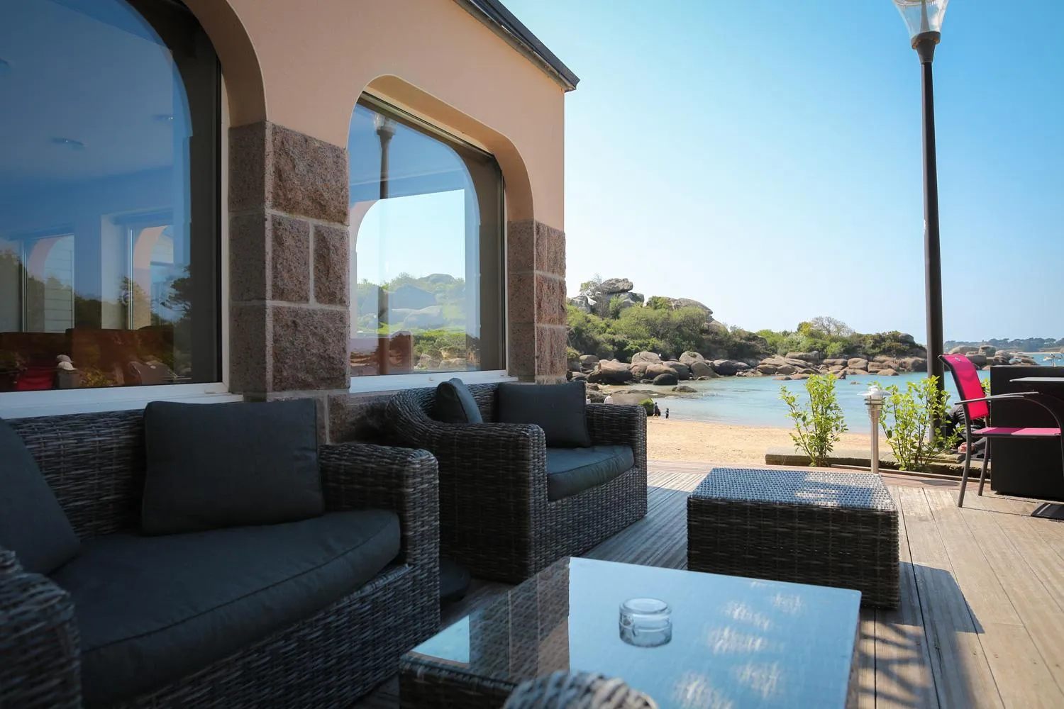 Espace de détente extérieur avec mobilier confortable et vue sur la mer.