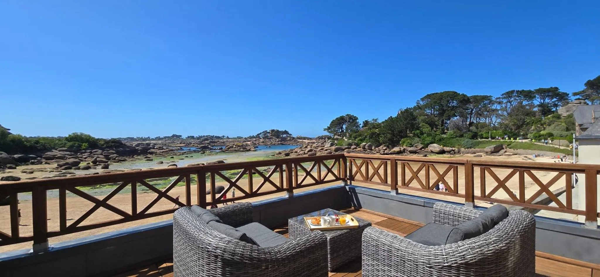 Terrasse aménagée avec mobilier de jardin et vue sur la mer.