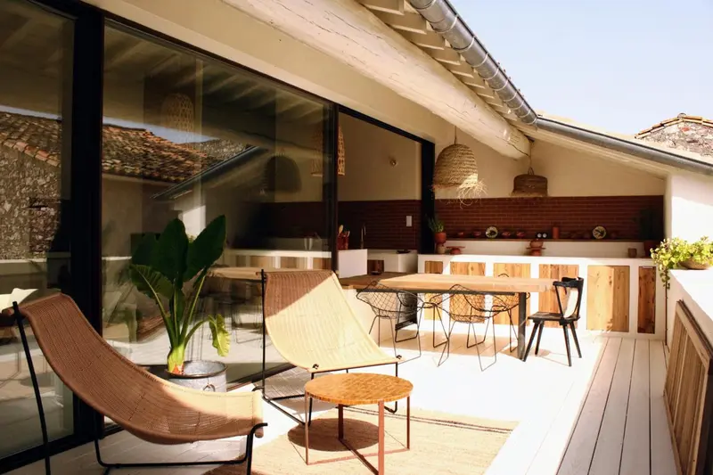 Espace extérieur aménagé avec mobilier de détente et table à manger.
