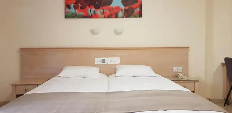 Un lit double avec des oreillers blancs dans une chambre lumineuse.