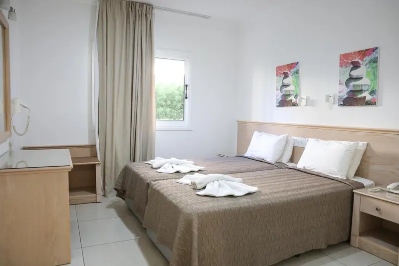 Une chambre lumineuse avec un lit double et des tables de chevet.