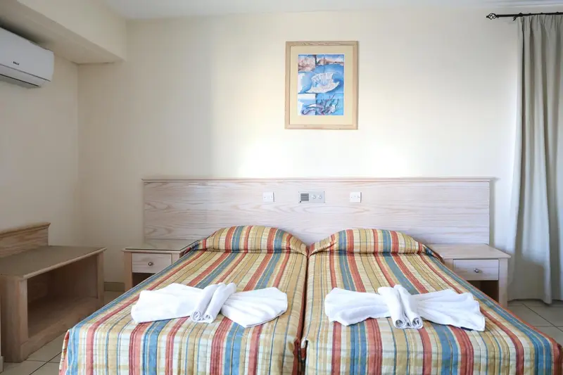 Une chambre lumineuse avec un grand lit et une décoration murale.
