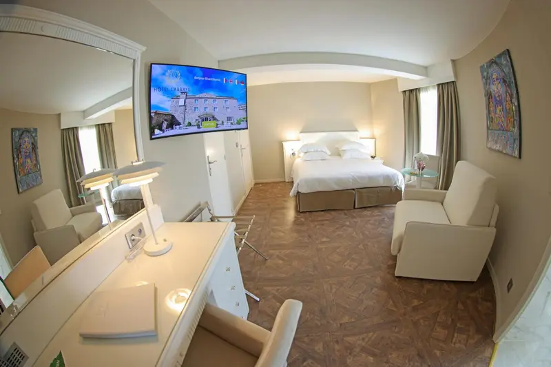 Une chambre lumineuse avec un lit double et un espace bureau.